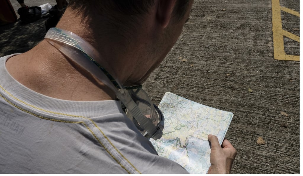 Tait checks a map before a canyoning session in the New Territories. Photo James Wendlinger
