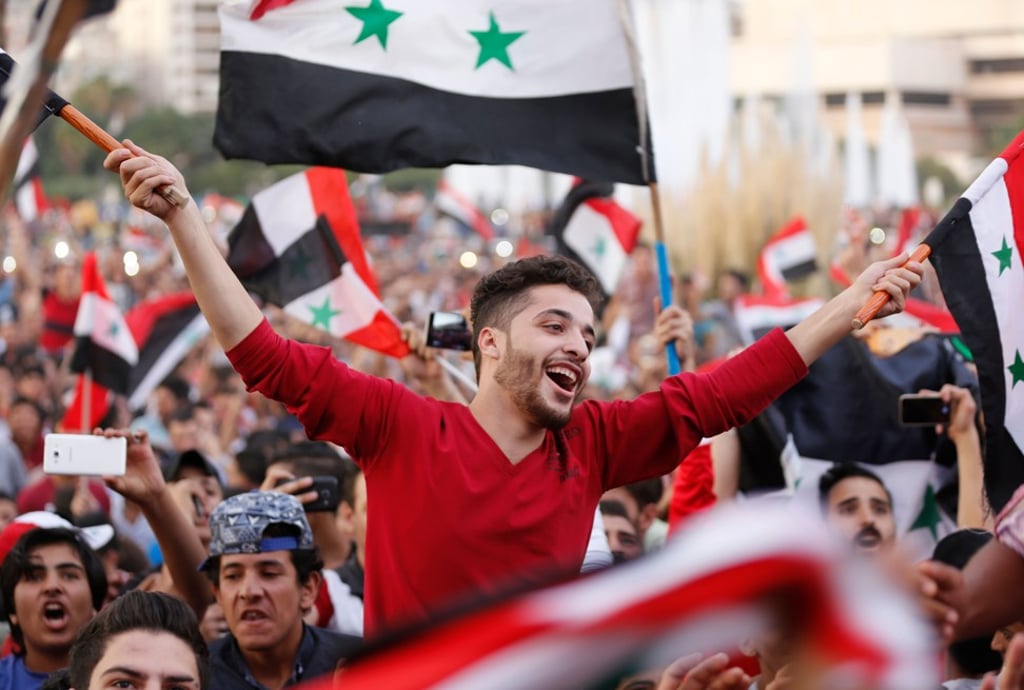 Syrians wave their national flag as they celebrate scoring in the first leg of the Fifa World Cup 2018 qualifier against Australia. Photo: AFP Syrians wave their national flag as they celebrate scoring in the first leg of the Fifa World Cup 2018 qualifier against Australia. Photo: AFP