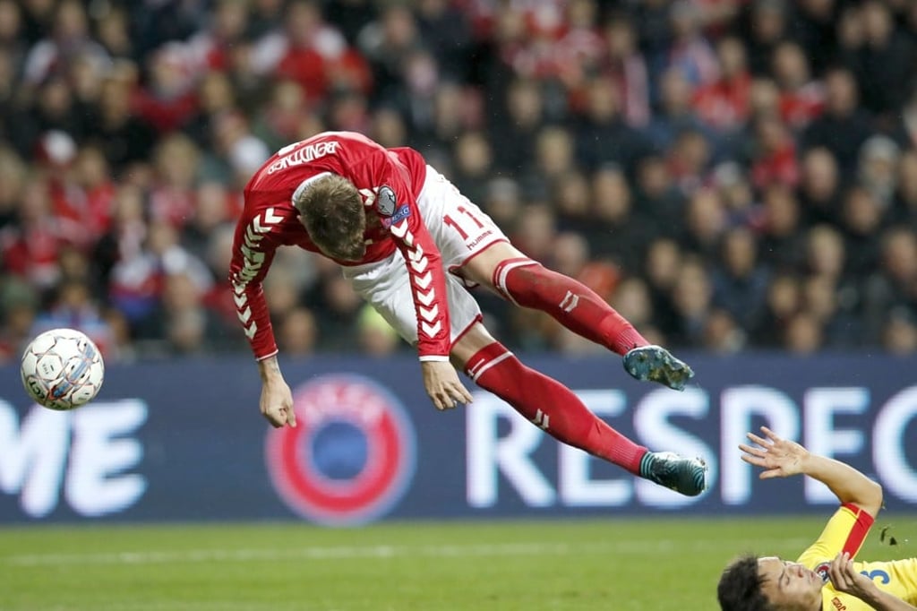 Romania’s Cristian Ganea (R) was sent off for a late tackle on Denmark’s Nicklas Bendtner during their group E qualifier. Photo: AP