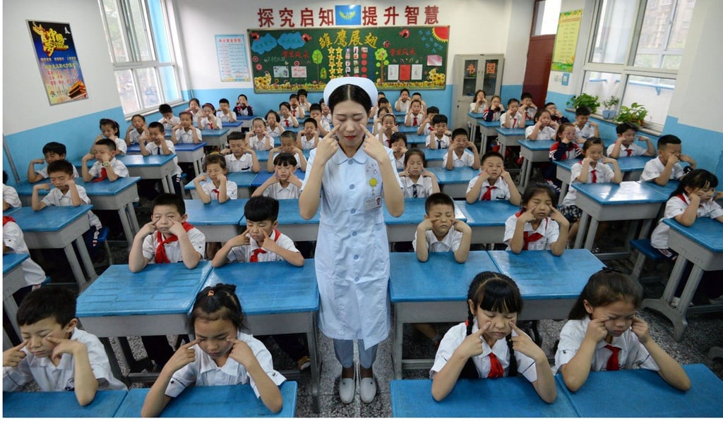 A hospital staff member teaches primary school children how to do eye exercises, at a primary school in Handan, in China's northern Hebei province. Photo: AFP