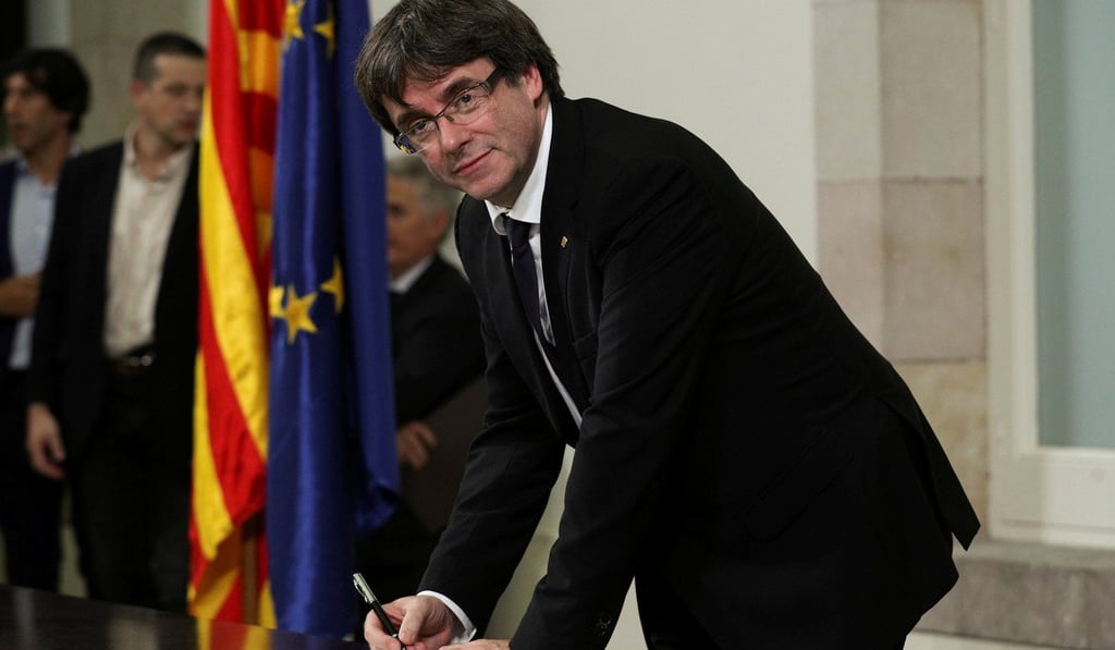 Catalan President Carles Puigdemont signs a declaration of independence at the Catalan regional parliament in Barcelona, Spain. But he announced that the measure would not be enforced pending the pursuit of talks with Madrid. Photo: Reuters
