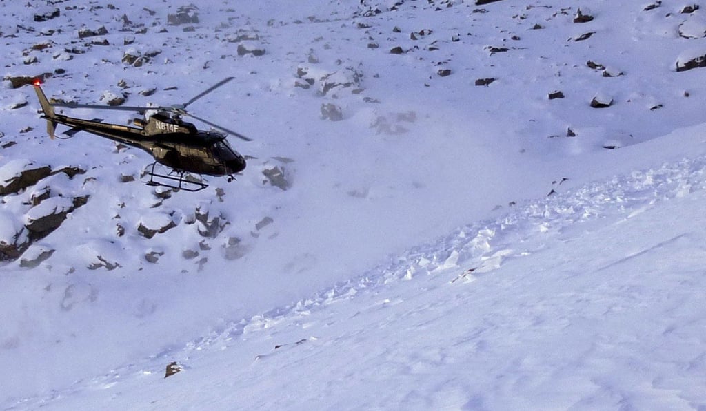 A helicopter searches avalanche debris for a missing skier on Imp Peak in the southern Madison Range in southwestern Montana. The body of Inge Perkins was recovered. Photo: AP A helicopter searches avalanche debris for a missing skier on Imp Peak in the southern Madison Range in southwestern Montana. The body of Inge Perkins was recovered. Photo: AP