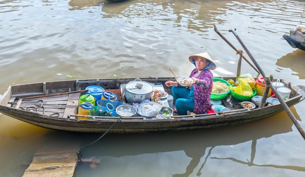 A woman sells noodles from her boat at a floating market in Bangkok.