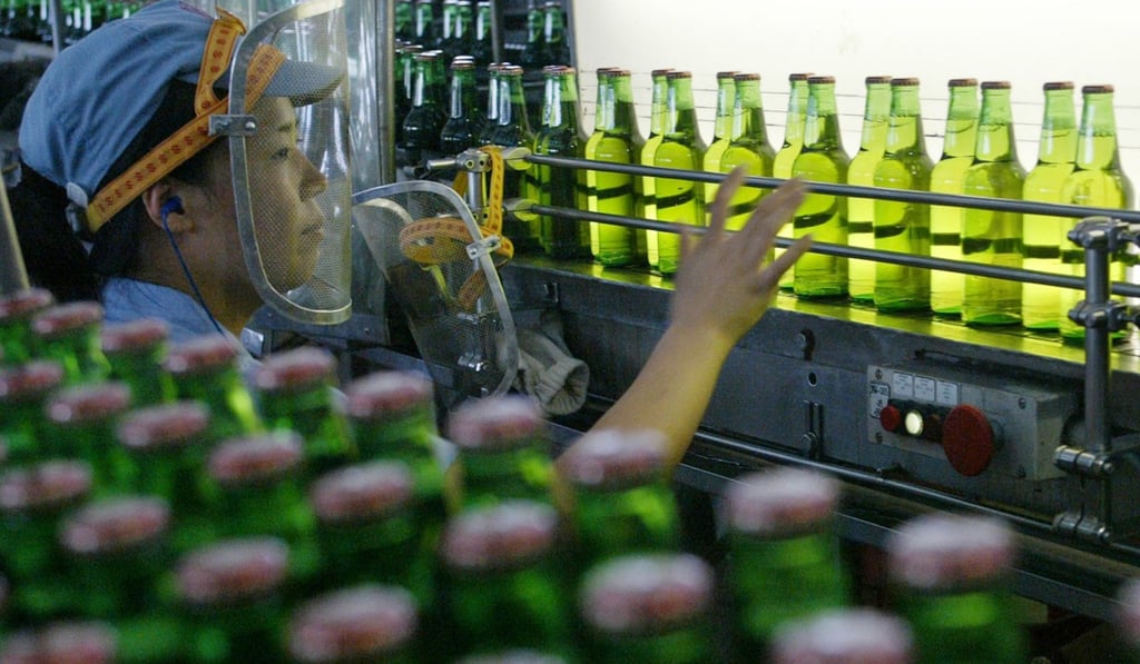 A worker checks bottles of Tsingtao beer on the production line of Tsingtao plant in China's eastern port city of Qingdao, Shandong province. The company is shifting its emphasis towards selling premium versions of the product. Photo: Reuters
