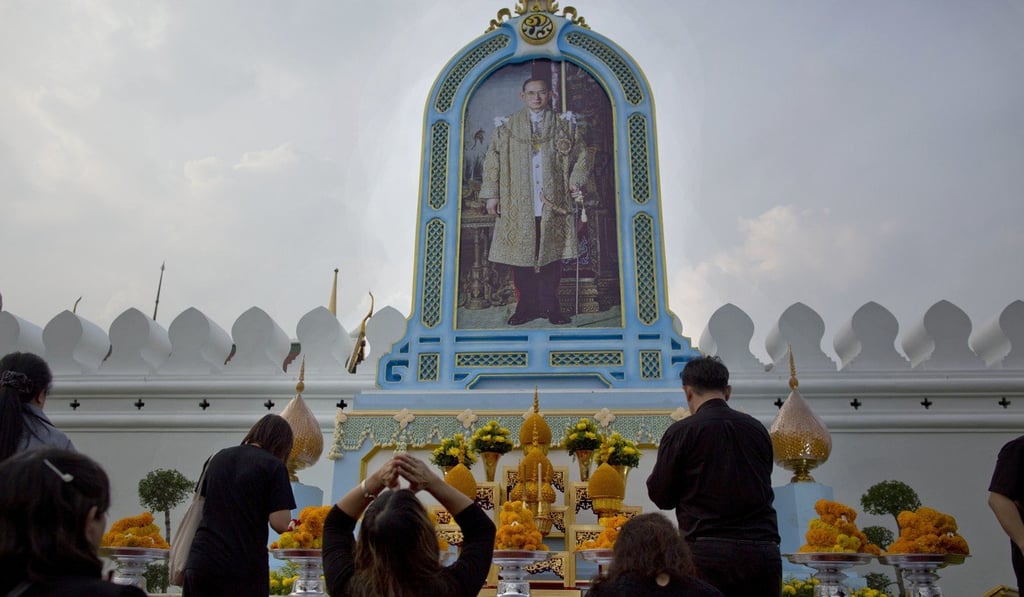 Mourners pay respects in front of a portrait of the late King Bhumibol Adulyadej outside the Grand Palace in Bangkok. Photo: AP