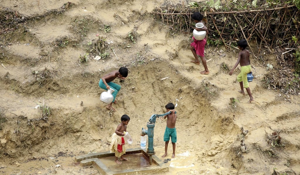Rohingya children collet water at a well near a camp for Rohingya refugees near Thangkhali. Photo: EPA