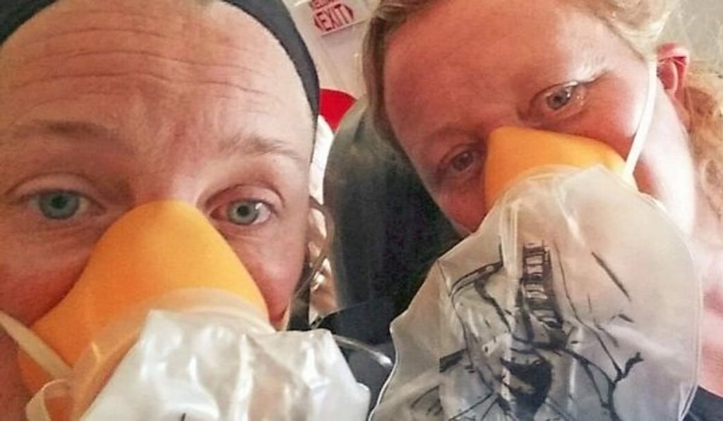 Passengers wearing oxygen masks on Flight QZ535 to Bali on Sunday. Photo: Channel Seven Passengers wearing oxygen masks on Flight QZ535 to Bali on Sunday. Photo: Channel Seven