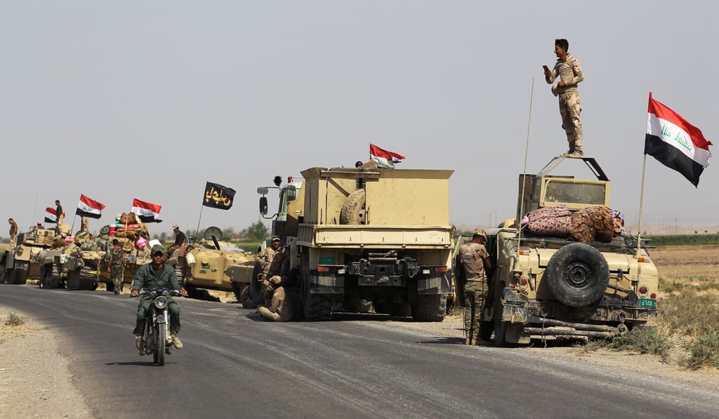 Iraqi forces stop on a road on their way towards Kurdish peshmerga. Photo: Agence France-Presse