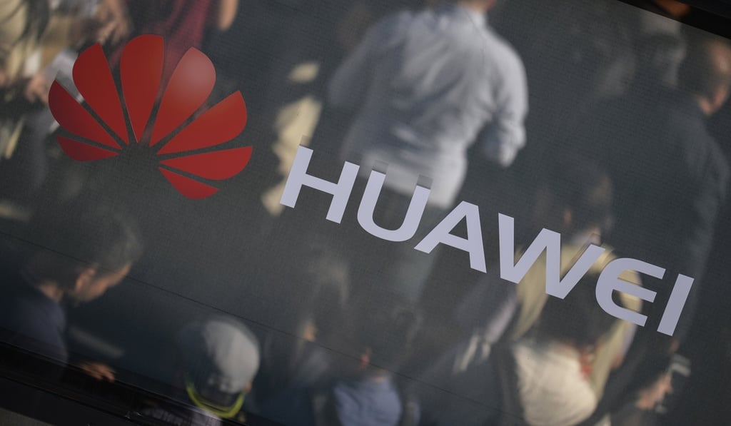 Visitors are reflected in a window with the Huawei company logo during the official launch event for the Huawei Mate 10 smartphone series in Germany. Photo: EPA-EFE
