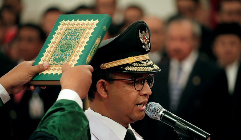 A man holds a Koran as Anies Baswedan is sworn in as Jakarta’s new governor. Photo: Reuters