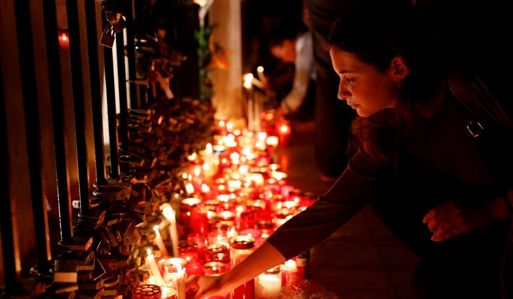 A woman places a candle during a candlelight vigil in memory of investigative journalist Daphne Caruana Galizia in St Julian's, Malta, on Monday. Photo: Reuters