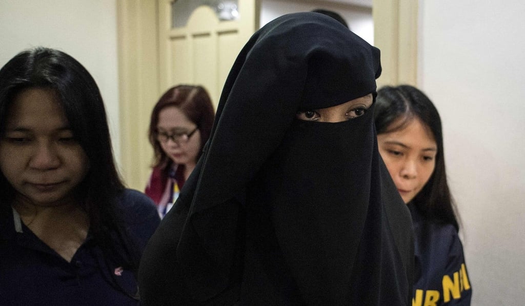 Karen Aizha Hamidon is escorted by National Bureau of Investigation personnel. The widow of an Islamic militant leader in the Philippines was arrested for allegedly recruiting fighters. Photo: Agence France-Presse
