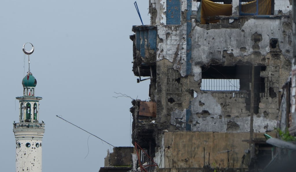 A damaged mosque minaret and buildings in Marawi. Photo: AFP