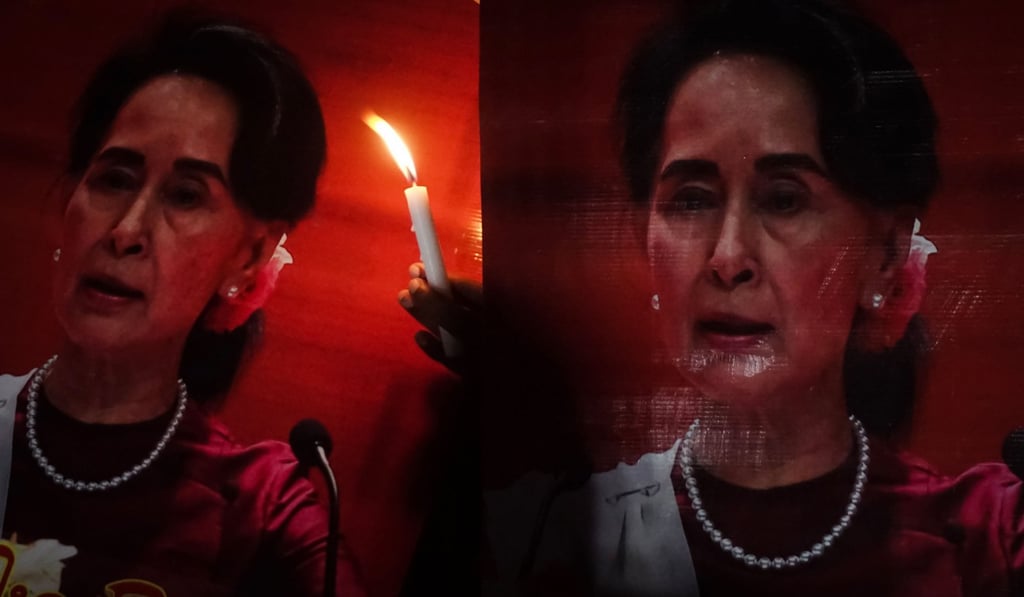 A woman holds a candle beside portraits of Myanmar's State Counsellor and civilian leader Aung San Suu Kyi during an interreligious gathering in Yangon to pray for peace, on October 17, in a display of support for her handling of the Rohingya crisis. Outside Myanmar, the Nobel Peace laureate has come under severe criticism for what many see as her refusal to acknowledge the reality of her government’s actions. Photo: AFP