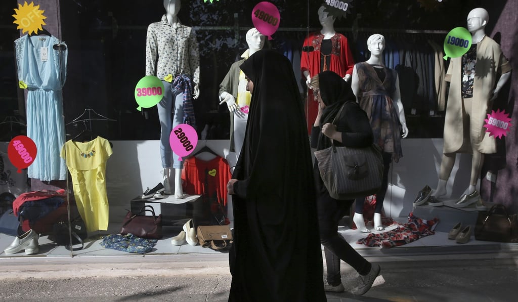 Iranian women walk past a clothes shop in downtown Tehran on October 14. Restrictions on trading and other foreign engagement with Iran were felt across its society, especially among the growing middle class. Photo: AP