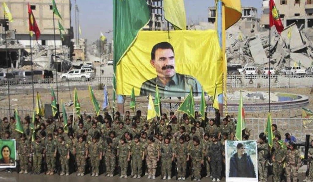 This frame grab from a video shows members of a Kurdish female militia, the Women's Protection Units, under a portrait of their jailed leader, Abdullah Ocalan, as they celebrate victory against the Islamic State group, in Raqqa, Syria, on Thursday. Photo: AP