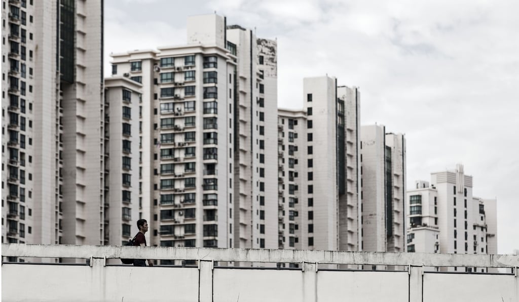 A man walks past residential buildings in Shanghai. China saw a huge credit expansion in 2016 as banks extended a record 12.65 trillion yuan of loans. It was driven by robust mortgage growth, despite government measures to cool housing prices. Photo: Bloomberg A man walks past residential buildings in Shanghai. China saw a huge credit expansion in 2016 as banks extended a record 12.65 trillion yuan of loans. It was driven by robust mortgage growth, despite government measures to cool housing prices. Photo: Bloomberg