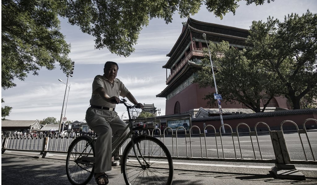 A man take a leisurely bike ride through a traditional hutong neighbourhood of Beijing. China’s economic expansion decelerated to 6.8 per cent in the third quarter from 6.9 per cent from the previous three-month period, as housing sales slowed, a trend expected to continue. Photo: Bloomberg