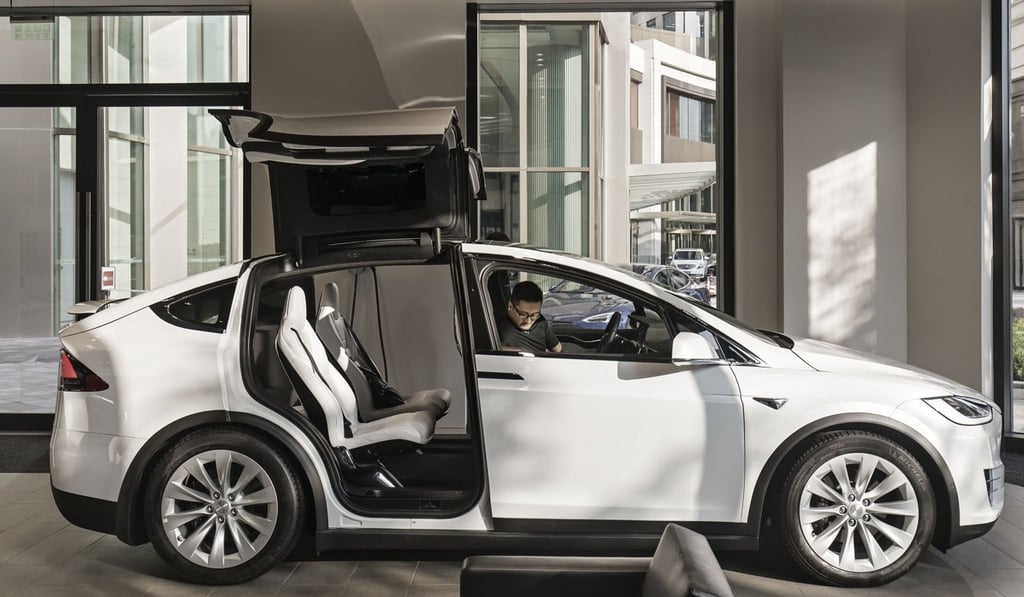 A customer sits inside a Tesla Model X electric vehicle on display at the company's showroom in Shanghai. Photo: Bloomberg