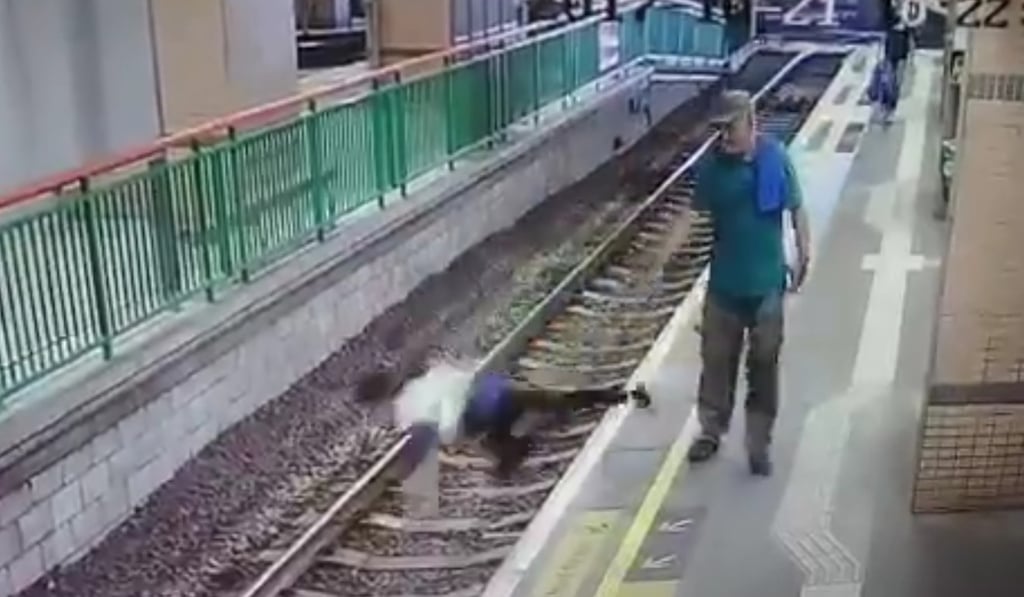 The woman is seen falling off platform No 5 after being pushed by the man (right). Photo: Facebook