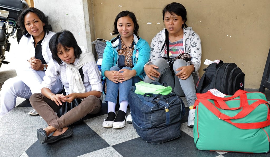 Newly arrived domestic helpers from Indonesia wait for their transportation to a maid agency in Singapore in 2012, not long after the Singaporean government’s decision to grant a mandatory weekly day off for foreign maids. Photo: AFP