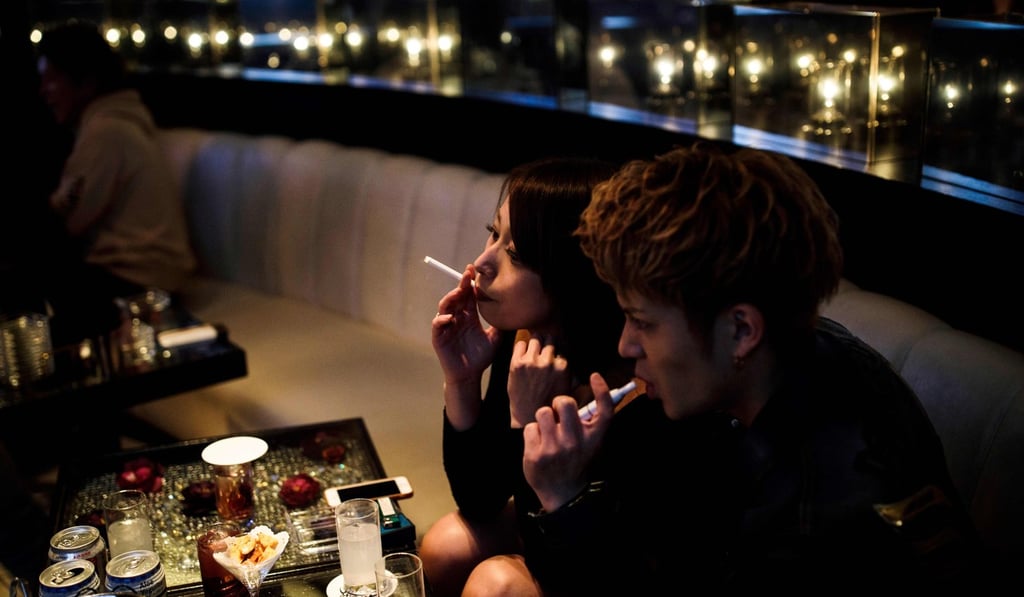 People smoke cigarettes inside a nightclub in Tokyo. Japan moved to install the strictest passive smoking laws ever. But resistance from some lawmakers stopped the zero tolerance approach from being introduced. Photo: AFP