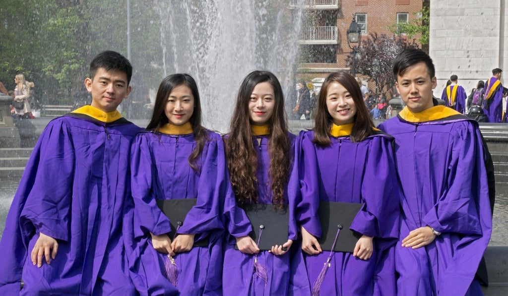 A group of Chinese students at NYU celebrating their graduation in Washington Square Park in Greenwich Village, Manhattan. Photo: Alamy Stock Photo