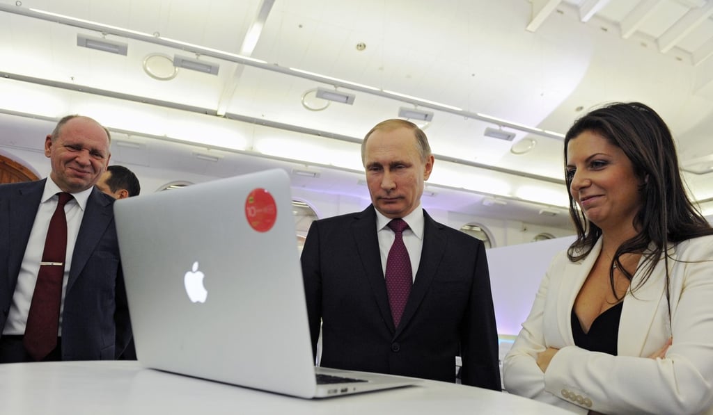 Margarita Simonyan, the editor-in-chief of state-funded RT television network, right, with Russian President Vladimir Putin, centre. Twitter said it will ban ads from RT and another Russian media outlet, Sputnik. Photo: AP