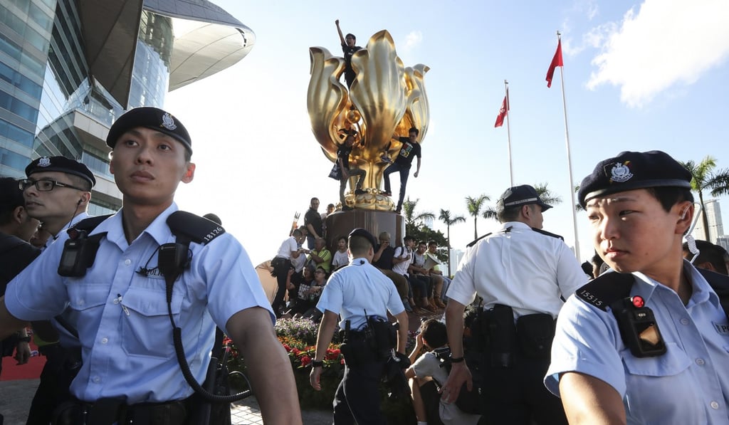 Activists protest at the Golden Bauhinia statue for the release of now-deceased rights activist Liu Xiaobo and for universal suffrage, at the Convention and Exhibition Centre on June 28. Photo: Nora Tam