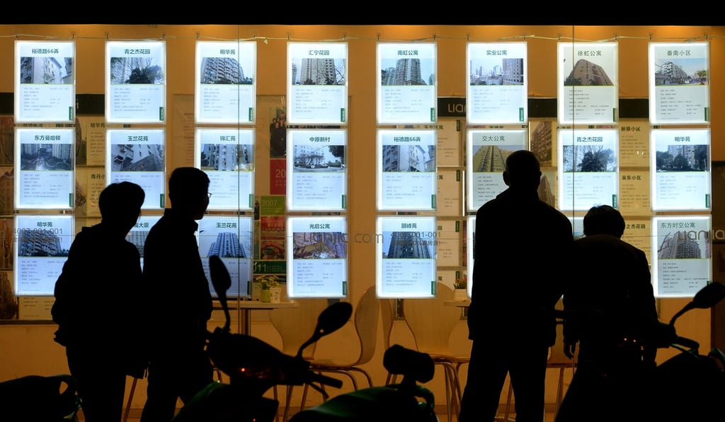 Potential customers scan real estate advertisements posted on the window of an agency in Shanghai. Photo: Lai Xinlin