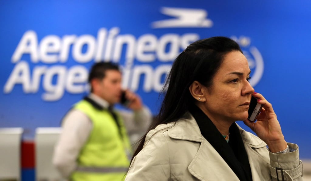 A passenger uses her mobile phone in front of an airport security officer at a closed counter of Argentina's flagship air carrier Aerolineas Argentinas at Buenos Aires airport, Argentina, on October 31, 2017. Photo: Reuters