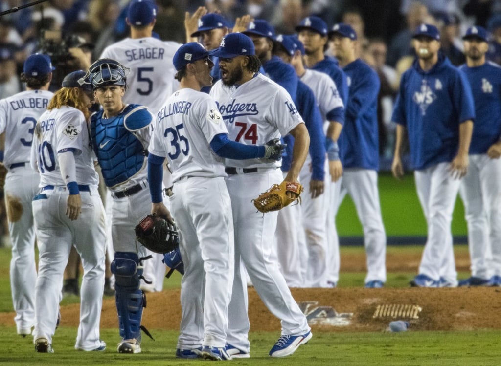 Los Angeles Dodgers relief pitcher Kenley Jansen (74) embraces first baseman Cody Bellinger (35) after the final out in a 3-1 win against the Houston Astros. Photo: TNS