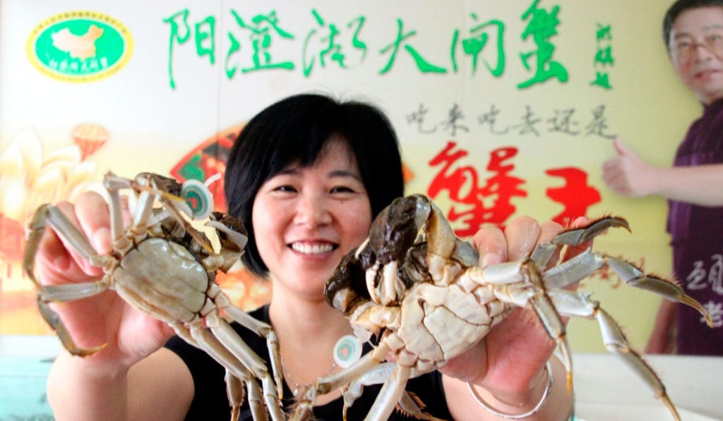 A vendor in Suzhou holds up Yangcheng Lake hairy crab. Photo: Alamy
