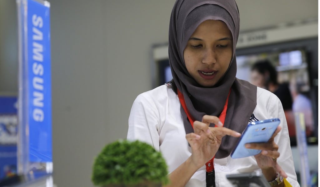A customer in Jakarta holds a smartphone. Indonesia is one country that has seen a considerable increase in online activity through smartphone use in recent years. Photo: Reuters