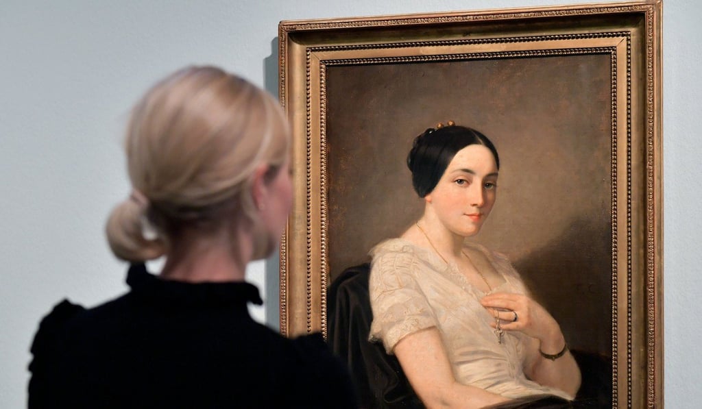 A visitor looks at a painting titled 'Portrait de jeune femme assise' (Portrait of a Sitting Young Woman) by French artist Thomas Couture, on display in the exhibition 'Gurlitt: Status Report Nazi Art Theft and its Consequences' at the Art and Exhibition Hall in Bonn, Germany. Photo: EPA-EFE
