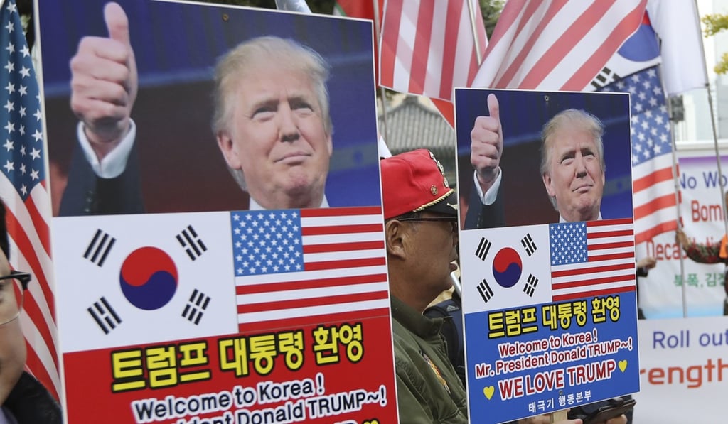 South Koreans hold banners with pictures of Donald Trump during a rally welcoming the US president in Seoul, South Korea, on Friday, November 3, 2017. Photo: AP