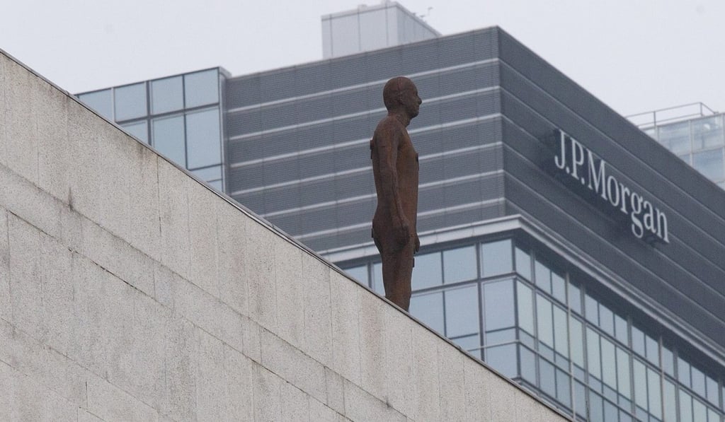 A sculpture of a lone figure by British artist Antony Gormley stands on a rooftop ledge of a building in Hong Kong's financial district, in Central Hong Kong. Photo: EPA