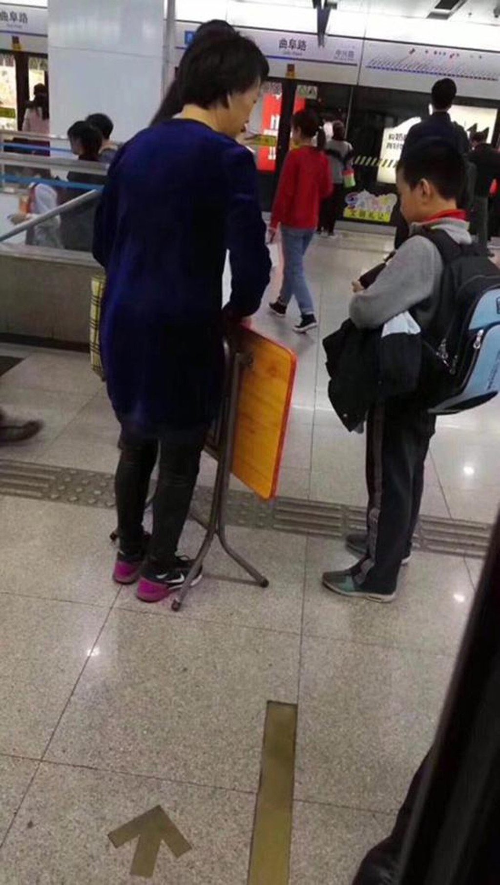 The youngster and his mother and pictured on a Shanghai subway station with the folding table that whipped up a social media storm. Photo: News.sina.com.cn