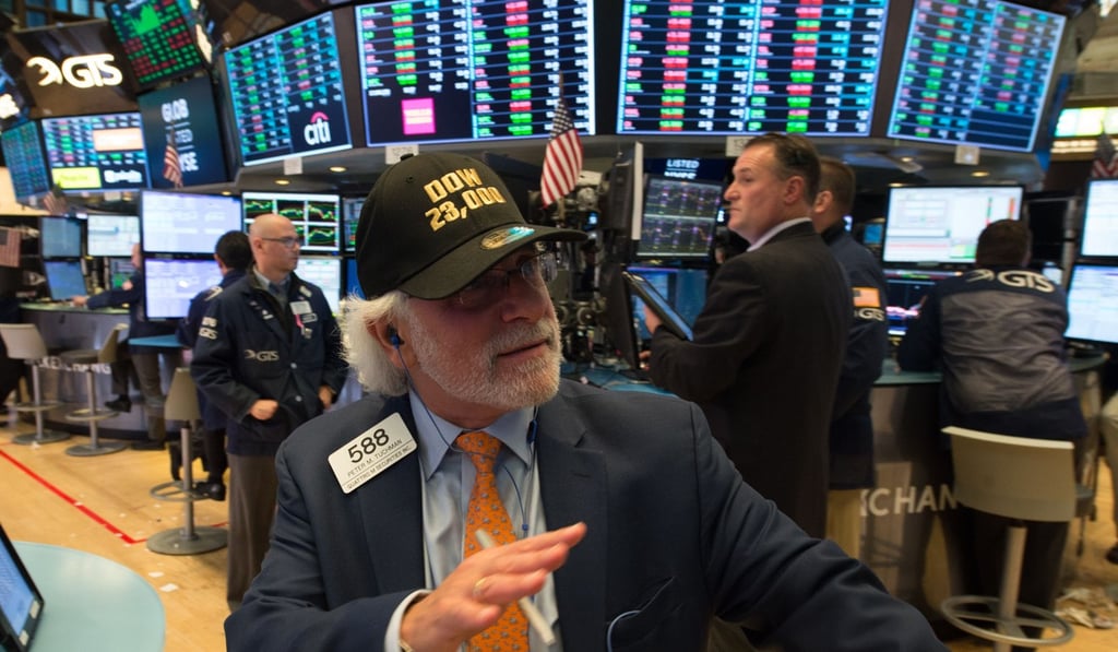 A NY trader sporting a ‘DOW 23,000’ hat while on the floor at the closing bell of the Dow on October 18. Market sentiment around the world appears to be showing equal calm. Photo: AFP