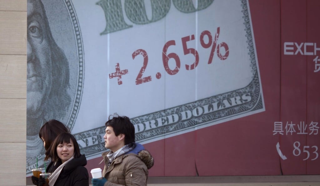 Chinese pedestrians walk past a giant US dollar note on a display board of a bank in Beijing. Photo: AP