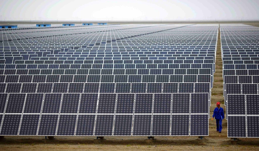 A worker inspects panels at a solar farm in Dunhuang, in Gansu Province. Photo: Reuters