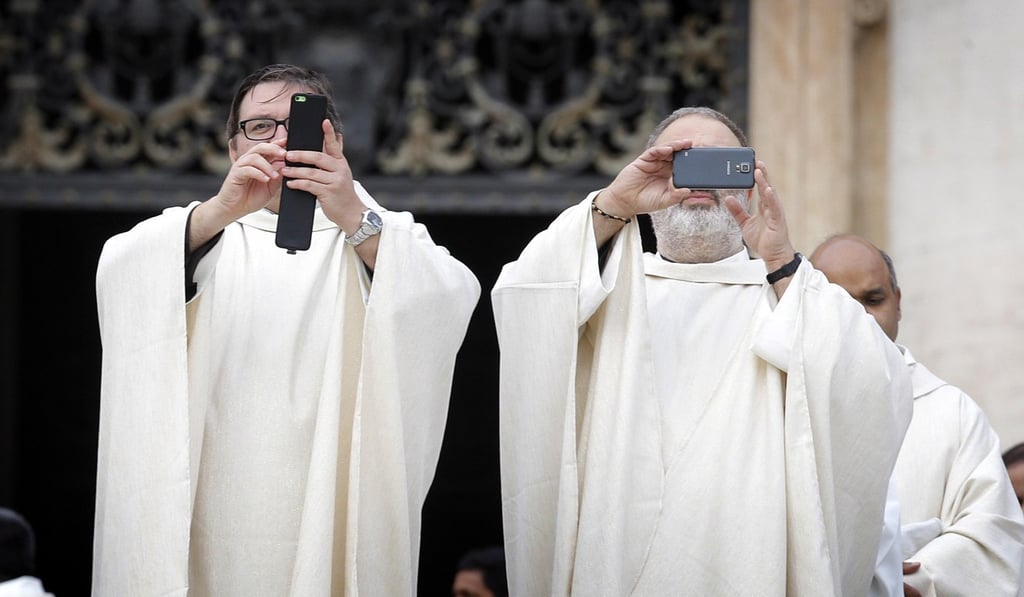 File photo of clergymen taking pictures with their mobile phones as during canonisation ceremony. Photo: EPA