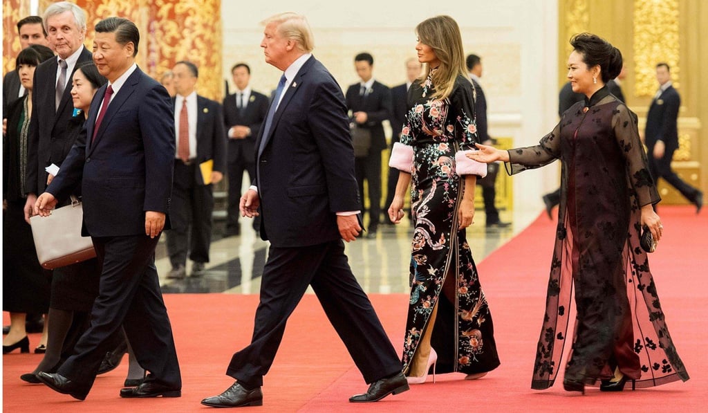 Peng Liyuan, wife of China's President Xi Jinping, gestures toward US President Donald Trump and US First Lady Melania Trump in the Great Hall of the People in Beijing on November 9, 2017. Photo: AFP