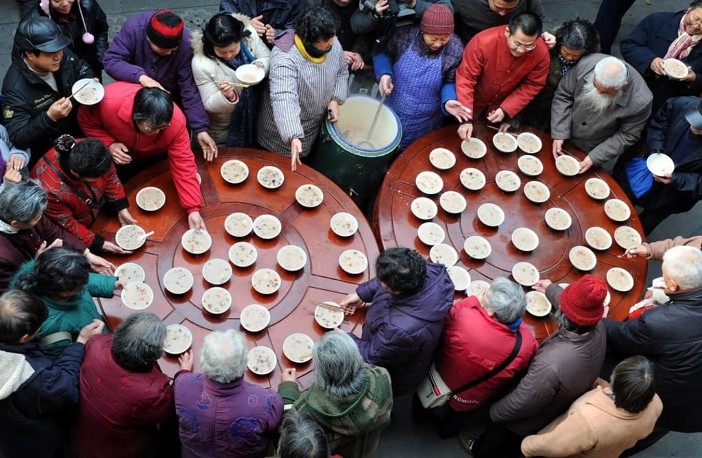 People enjoy traditional “eight treasures” congee at the Xuanzang Temple, in Nanjing. The ingredients include beans, dried fruits and nuts. Picture: Xinhua