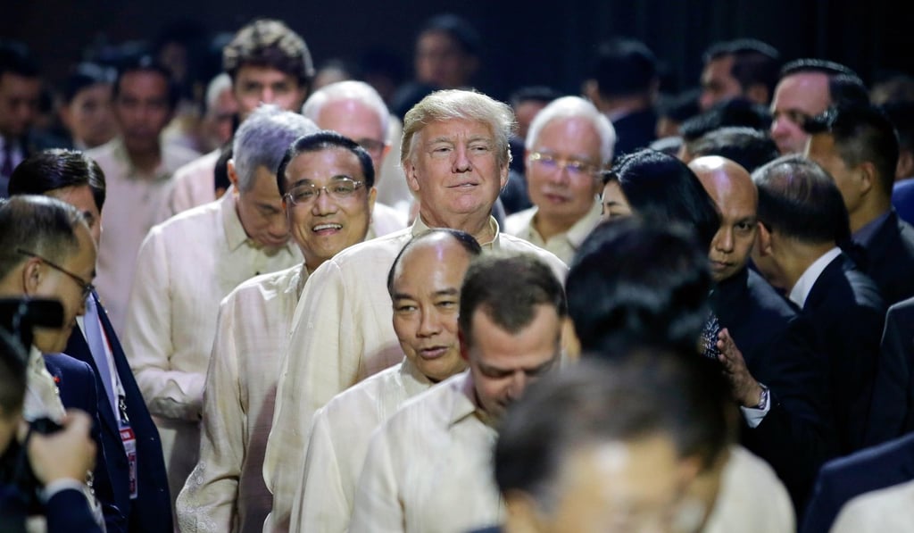 Trump smiles in front of Premier Li Keqiang as they queue to enter the gala dinner. Photo: EPA