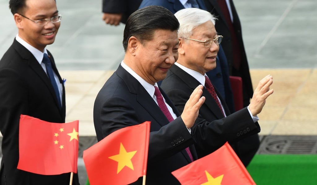 Chinese President Xi Jinping and Vietnam's Communist Party Secretary General Nguyen Phu Trong wave during a welcoming ceremony at the presidential palace in Hanoi on November 12. Photo: AFP