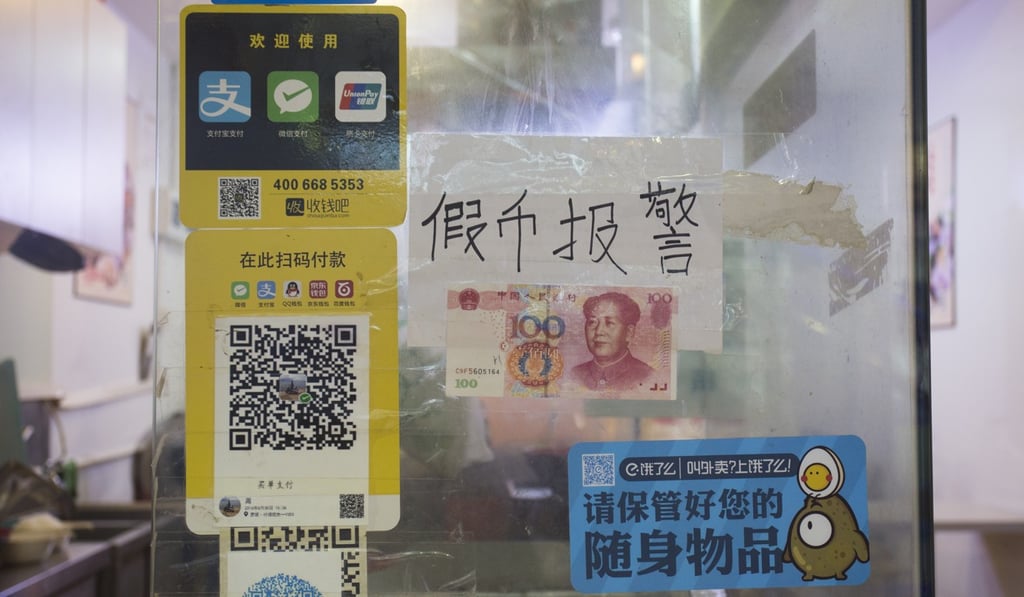 Signs on a shop in Shenzhen’s Dongmen Ding Plaza in August say it accepts mobile payments and warn shoppers not to present fake banknotes. Photo: May Tse