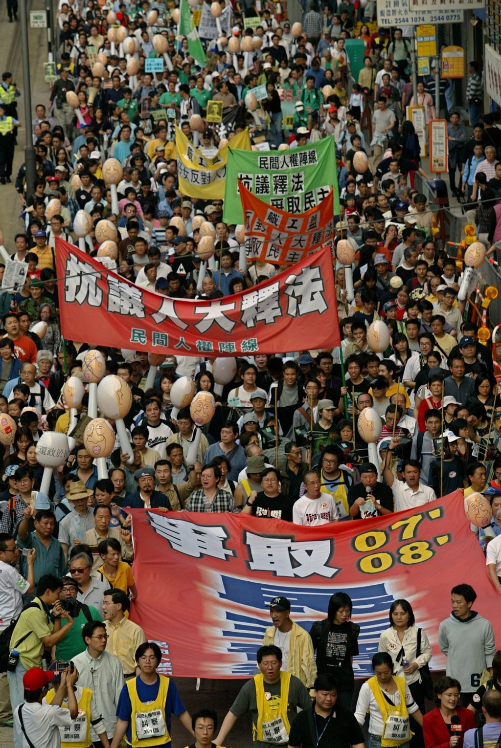Protesters carrying banners reading “Fight For Democratic Elections in 2007 and 2008”, and inflatable dolls depicting then Hong Kong chief executive Tung Chee-hwa, march to the central government’s liaison office to protest against Beijing’s interpretation of the Basic Law, in April 2004. Photo: SCMP Pictures