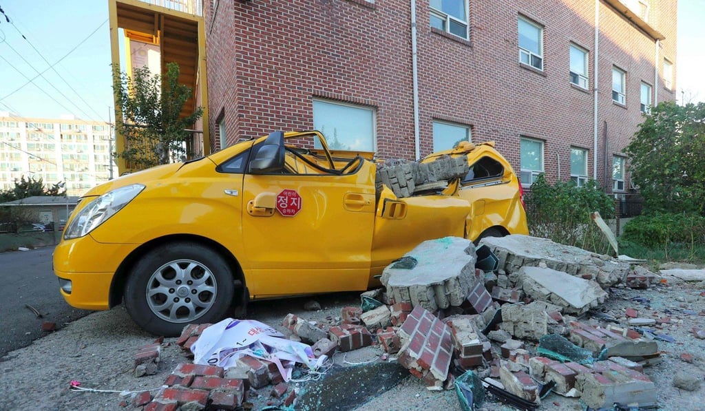 A car damaged by falling bricks. Photo: AFP A car damaged by falling bricks. Photo: AFP