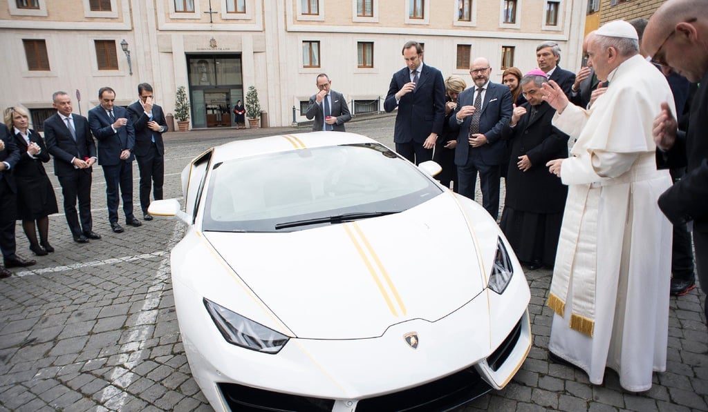 Pope Francis blesses a white Lamborghini, which he plans to auction to help fund a home for Christian women victims of trafficking at the hands of Islamic State in Iraq. Photo: AP